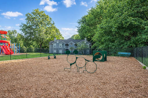 Playground area with wood chips and climbing equipment at Delta Crossing Apartments, Charlotte, NC 28212