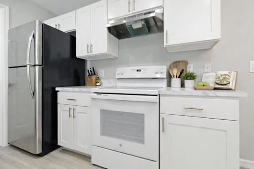 A modern kitchen with white appliances and cabinets.