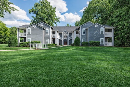 Two story apartment buildings with green lawn at Delta Crossing Apartments, Charlotte, NC