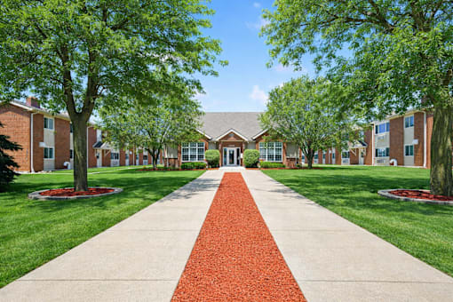 A red brick pathway leads to a building entrance.
