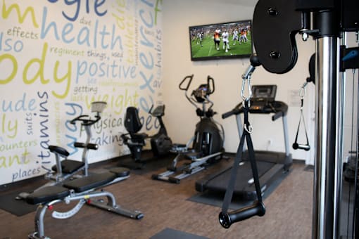 A gym with a wall covered in words related to health and fitness.