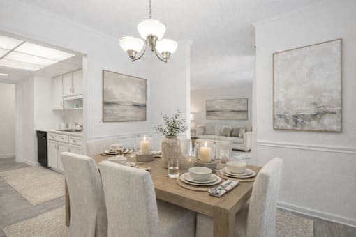 A dining room with a table set for two with candles on the table.