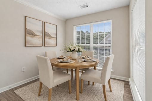 A dining room with a round table and chairs.