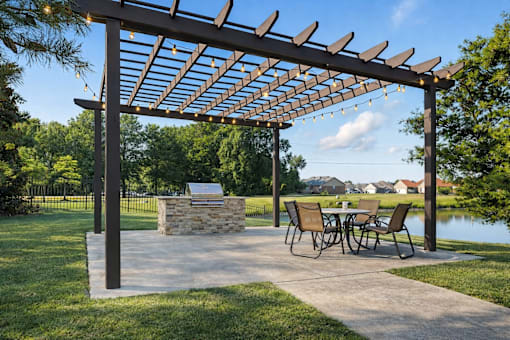A patio with a table and chairs under a pergola.