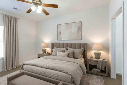 A bedroom with a large bed and a ceiling fan.