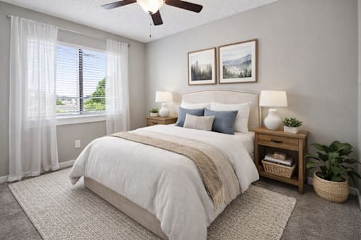 A bedroom with a large bed, a ceiling fan, and a window with curtains.
