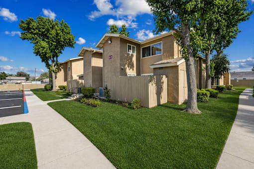 A row of houses with a sidewalk in front.