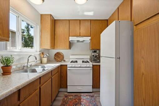 A kitchen with wooden cabinets and a white refrigerator.