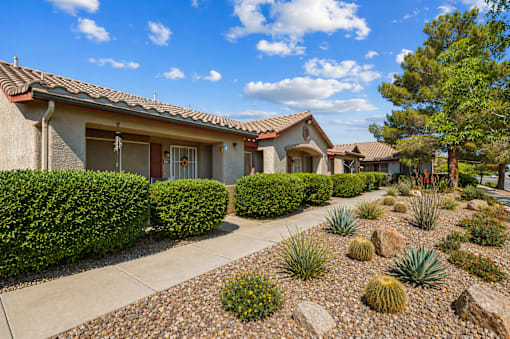 A house with a red tile roof and a well-maintained garden in front.