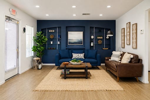 A living room with a blue couch and a brown couch.