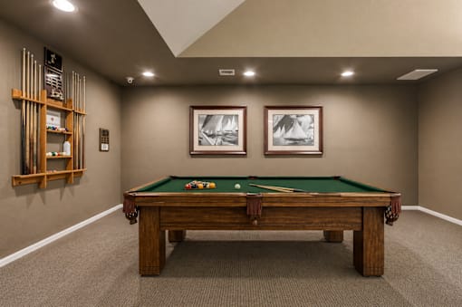 A pool table with two pool cues and two pool balls on it.