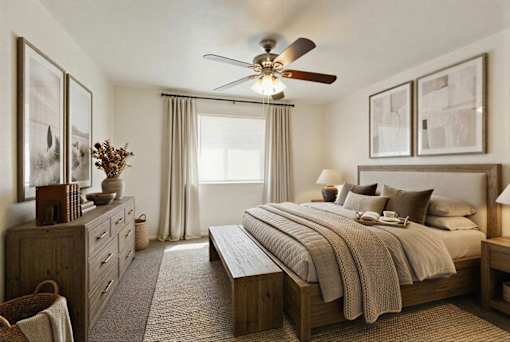 A bedroom with a large bed and a ceiling fan.