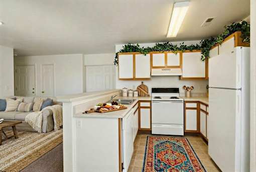 A kitchen with white appliances and wooden cabinets.