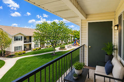 A balcony with a black railing and a green door.