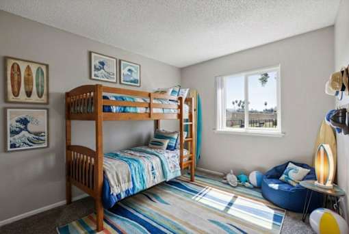 A room with two bunk beds and a blue bean bag chair.