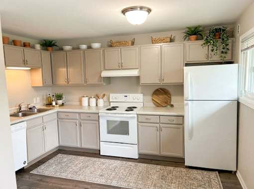A kitchen with white appliances and cabinets.