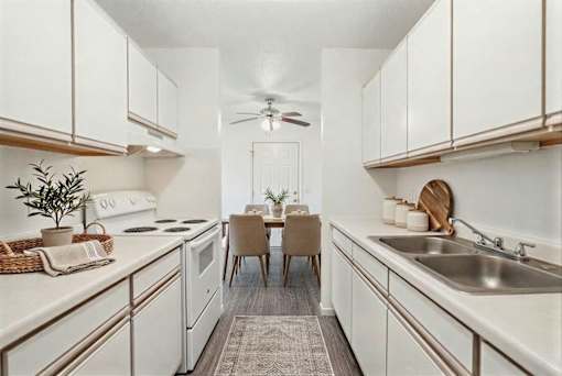 Galley kitchen with white cabinets and double sink at Carver Ridge Townhomes Apartments, Minnesota, 55318
