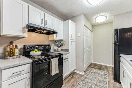 Kitchen with white cabinets and black appliances at Delta Crossing Apartments, Charlotte, NC 28212