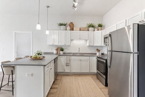 Modern kitchen with white cabinets and island at Lake Ridge Apartments, Minnesota, 55379