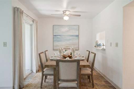 A dining room with a table set for four.