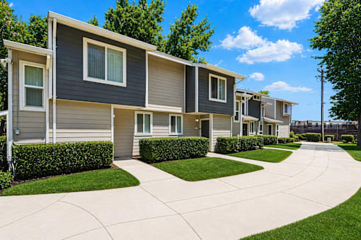 A row of modern houses with grey and beige siding.