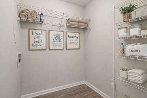 A laundry sign is on the wall above a shelf with towels.