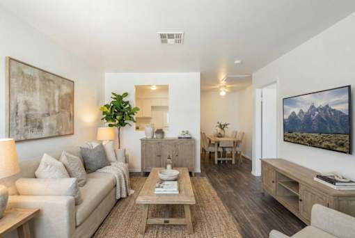A living room with a couch, a coffee table, and a painting on the wall.