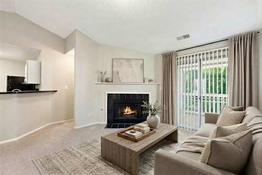 Living room with fireplace and sliding glass doors at Delta Crossing Apartments, Charlotte, North Carolina