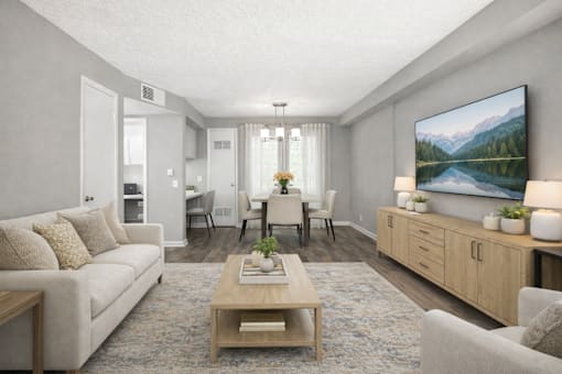 A living room with a large painting on the wall and a coffee table in the center.