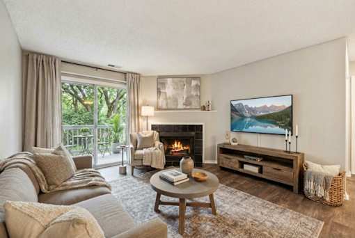 Living room with fireplace and balcony access at Delta Crossing Apartments, Charlotte
