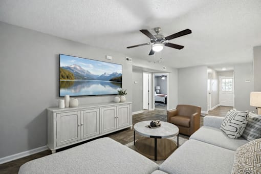 A living room with a flat screen TV mounted on the wall.