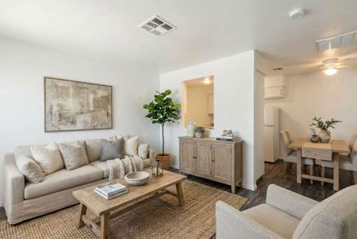 A living room with a couch, a coffee table, and a dining table.