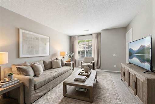 Living room with cozy seating and television at Delta Crossing Apartments, North Carolina