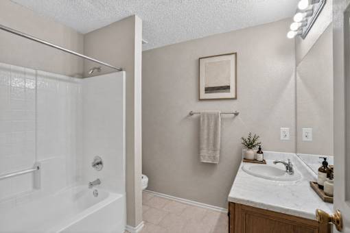 A bathroom with a white tub and sink.