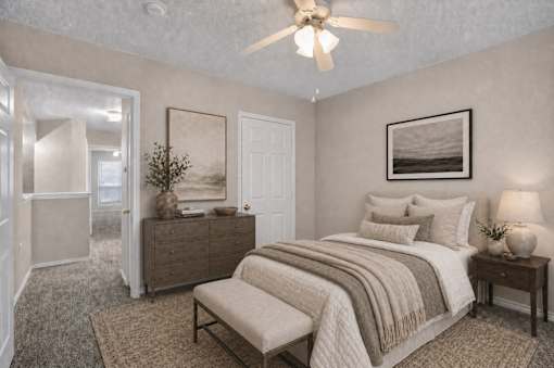 A bedroom with a bed, nightstand, and a ceiling fan.