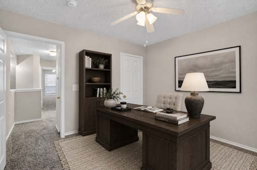 A room with a desk, chair, and bookshelf.