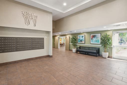 A hallway with a bench and a wall with pictures on it.
