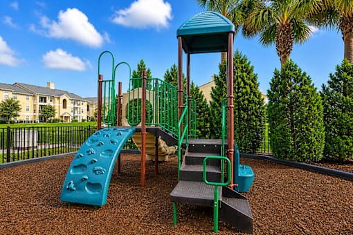 A playground with a blue slide and a green tower.