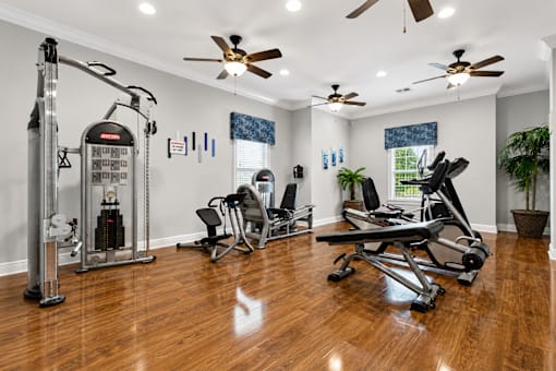 A home gym with a treadmill, exercise bike, and weights.