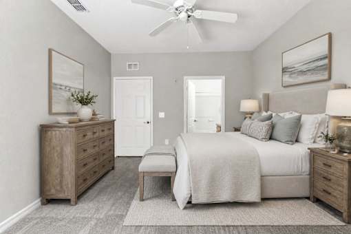 A bedroom with a bed, dresser, and nightstand.