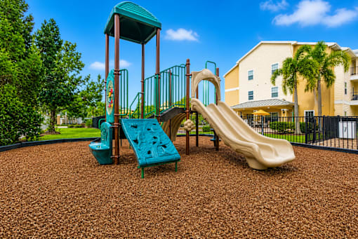 A playground with a green slide and a yellow slide.
