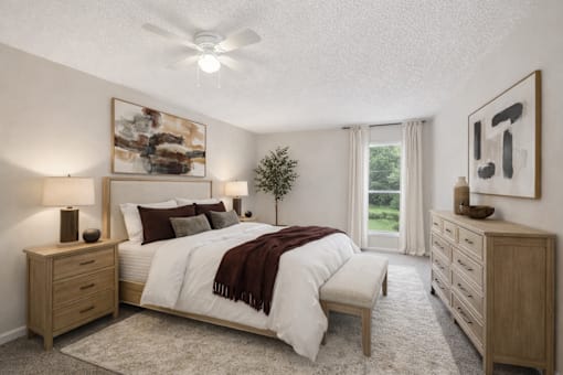 A bedroom with a bed, nightstands, and a ceiling fan.