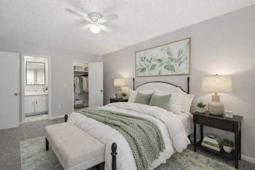 A bedroom with a large bed and a ceiling fan.