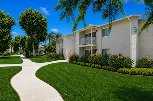 A white building with a green lawn in front.