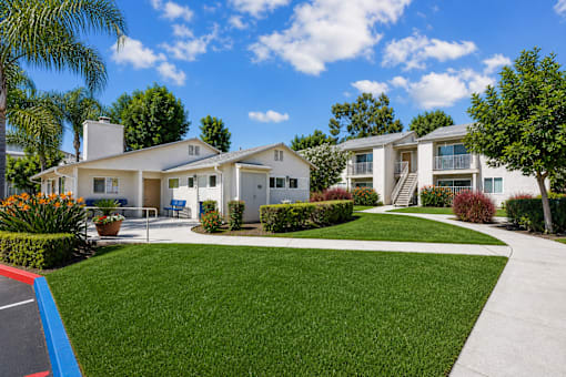A white house with a blue roof and a green lawn in front.