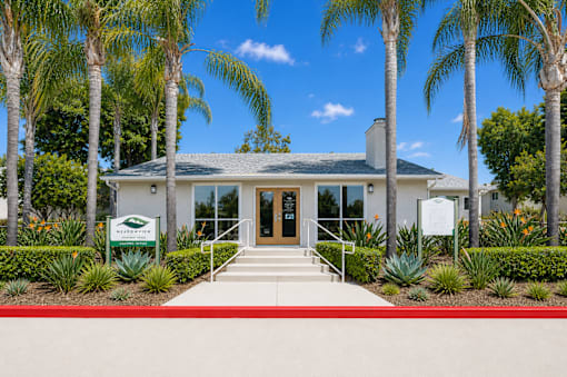 A building with a white facade and a red walkway in front.
