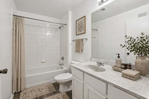 A bathroom with a toilet, sink, and shower.