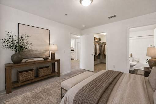 A bedroom with a large bed and a painting on the wall.