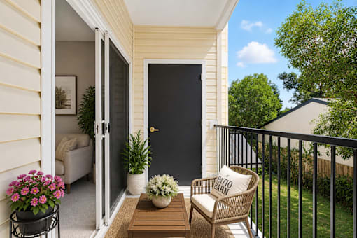 A balcony with a chair, table, and potted plants.