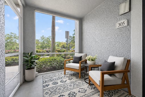A room with a chair and a table with a plant on it.